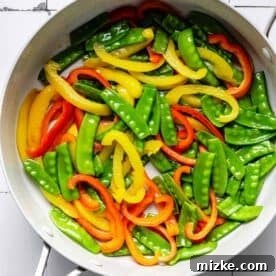 Sizzling Shrimp Noodle Delight 5 bell peppers and snow peas in a large nonstick skillet