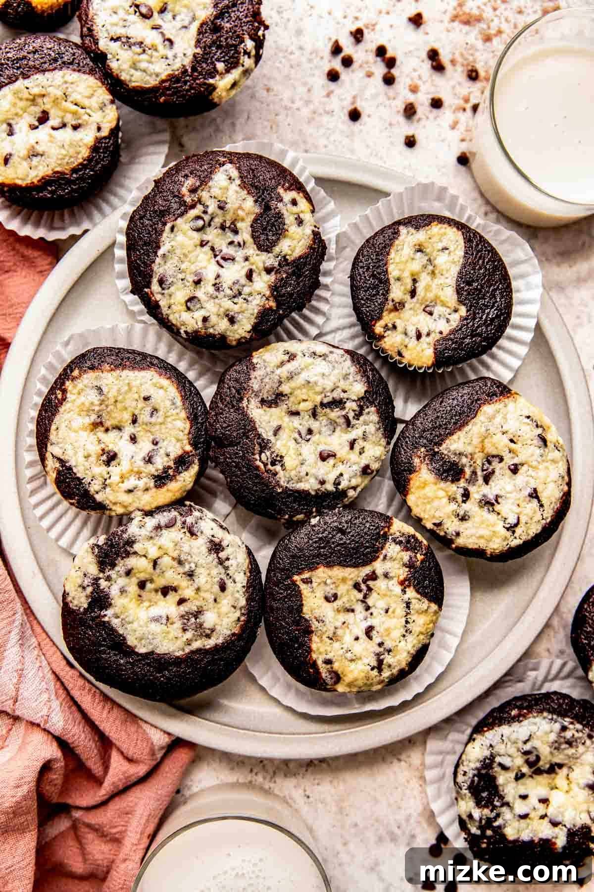 Decadent Chocolate Cream Cheese Cupcakes 2 A vibrant plate of chocolate cream cheese cupcakes, perfectly baked and ready to enjoy, alongside two glasses of fresh milk, inviting a delightful dessert experience.