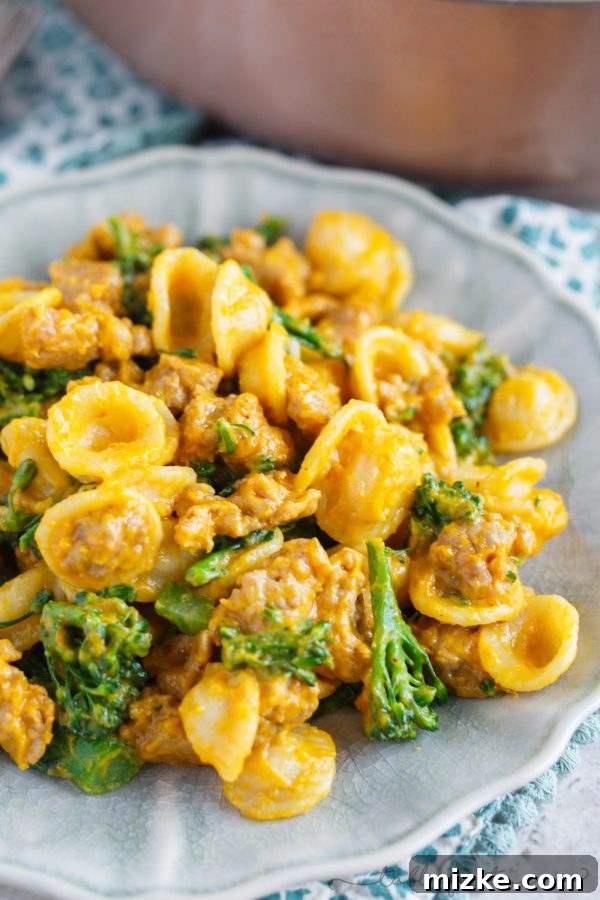 Zesty Sausage and Creamy Pumpkin Orecchiette with Broccolini 3 Close-up of orecchiette pasta coated in a rich pumpkin mascarpone sauce with spicy sausage and vibrant broccolini.