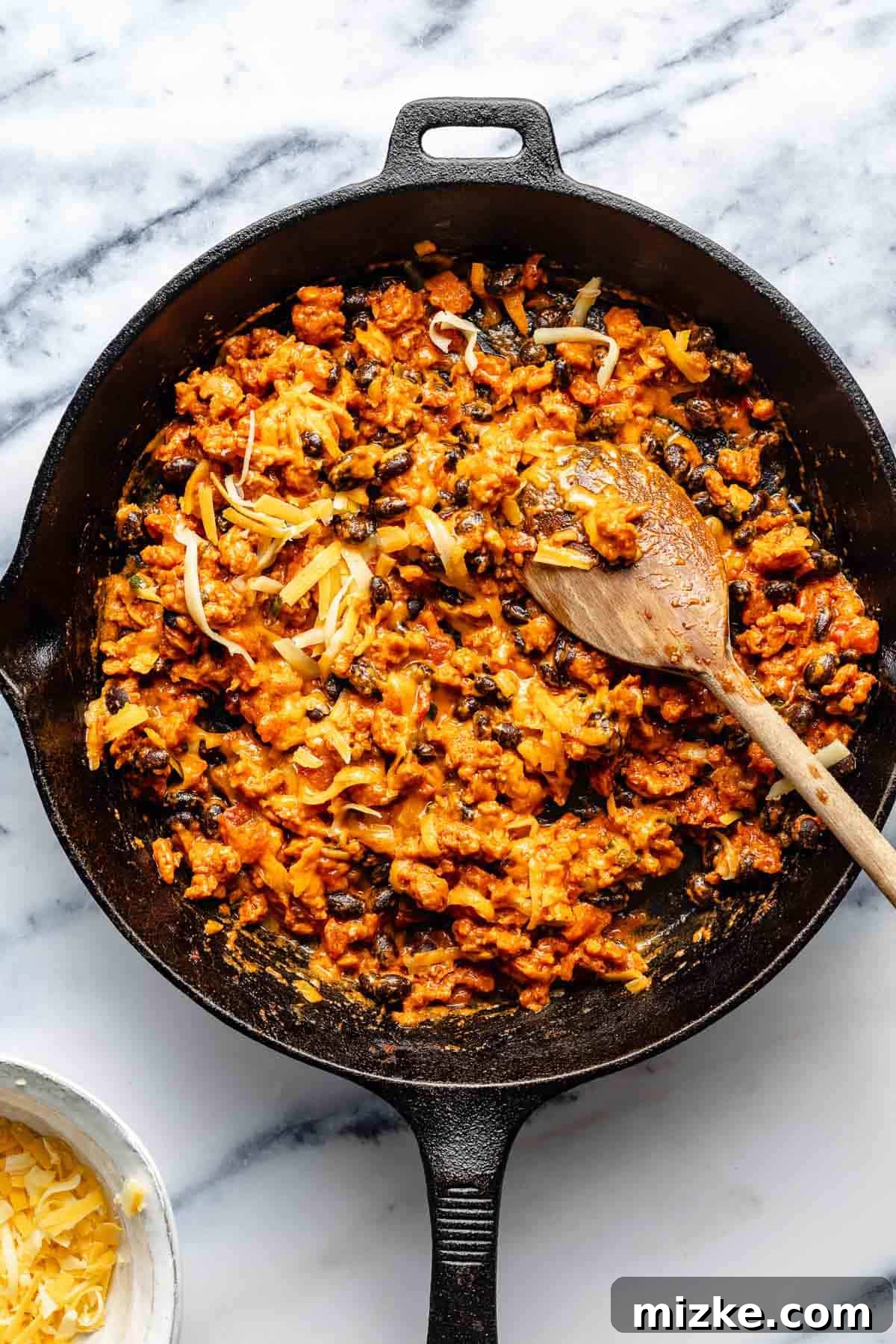 Easy to make and a bit too easy to eat, chili cheese dip is creamy, cheesy, and just the right amount of spicy from the chorizo and jalapeno. Stirring milk and cheese into chorizo dip.
