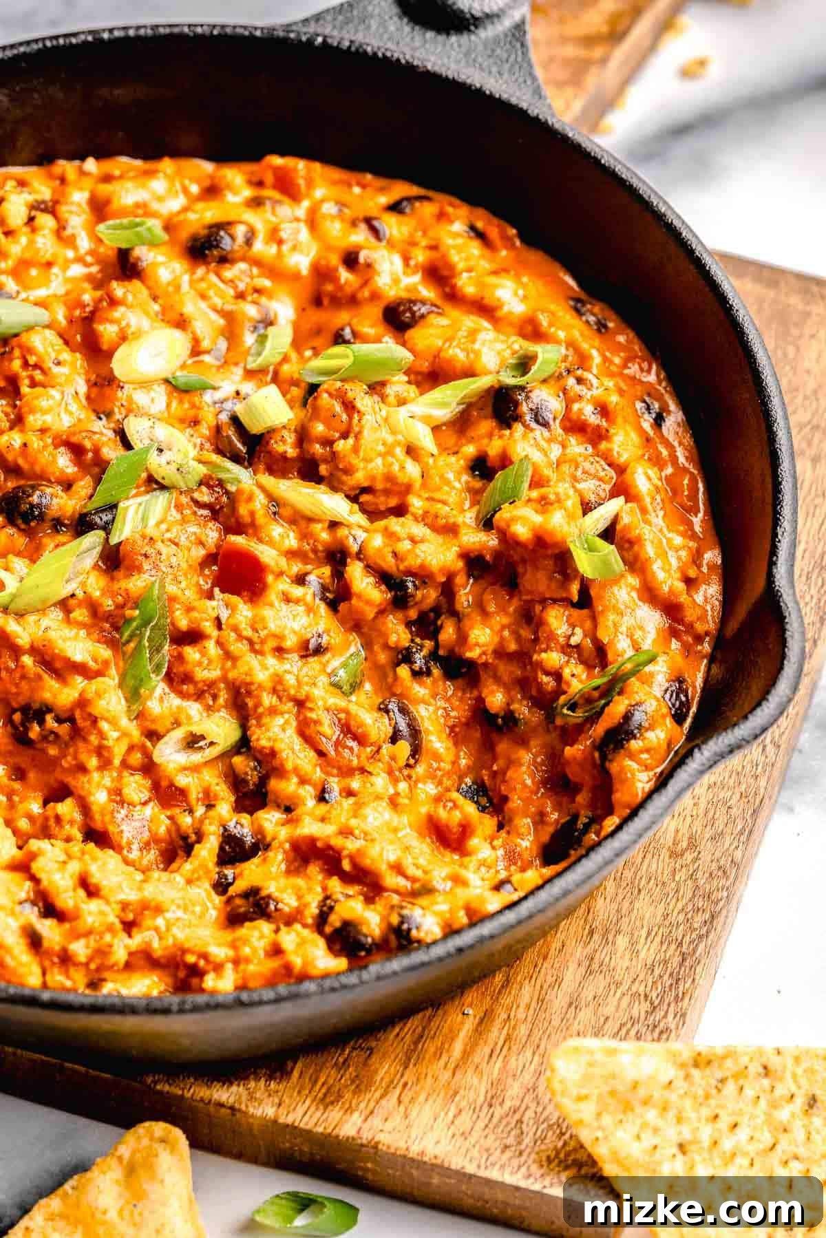 Easy to make and a bit too easy to eat, chili cheese dip is creamy, cheesy, and just the right amount of spicy from the chorizo and jalapeno. A skillet full of chili cheese dip.