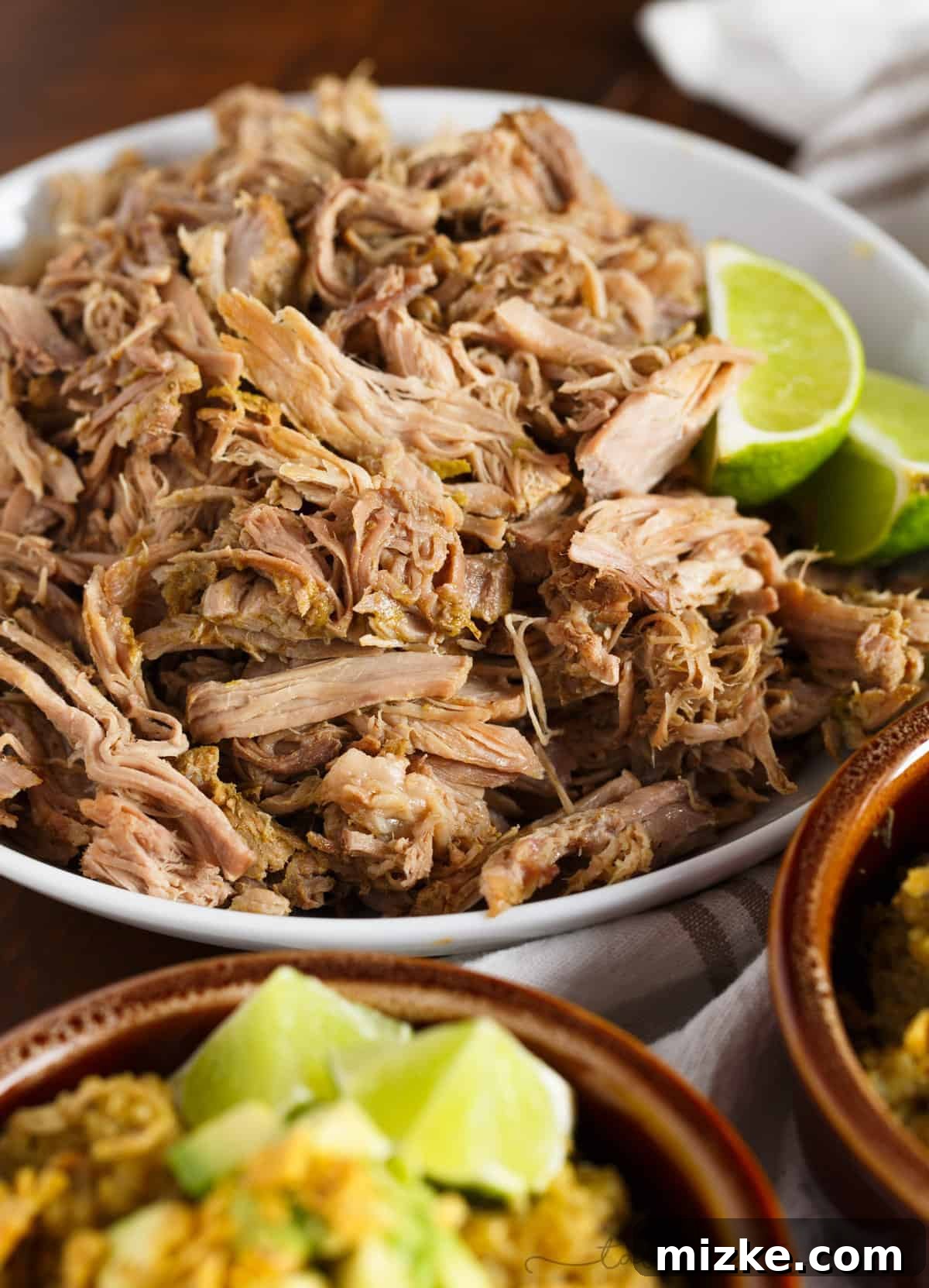 Zesty Slow Cooker Poblano Tomatillo Shredded Pork with Quinoa 3 Close-up shot of the tender, shredded pork infused with vibrant green poblano and tomatillo sauce, nestled on a bed of quinoa. The rich colors highlight the depth of flavor in this easy slow cooker recipe, ideal for a satisfying dinner that's both healthy and delicious.
