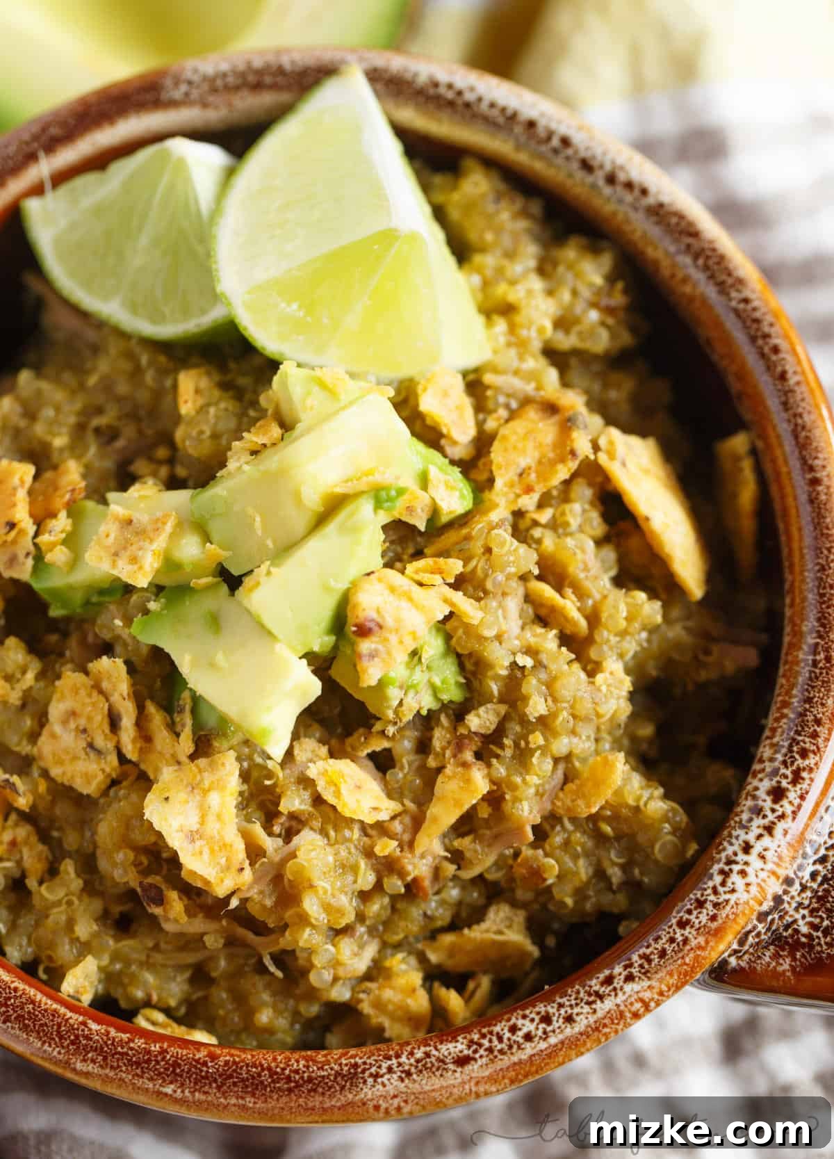 Zesty Slow Cooker Poblano Tomatillo Shredded Pork with Quinoa 4 A close-up of a fork piercing through the succulent, shredded pork and fluffy quinoa, showcasing the tender texture and rich sauce. This image emphasizes the readiness of the meal for serving after its slow cooking process, highlighting its delicious appeal.