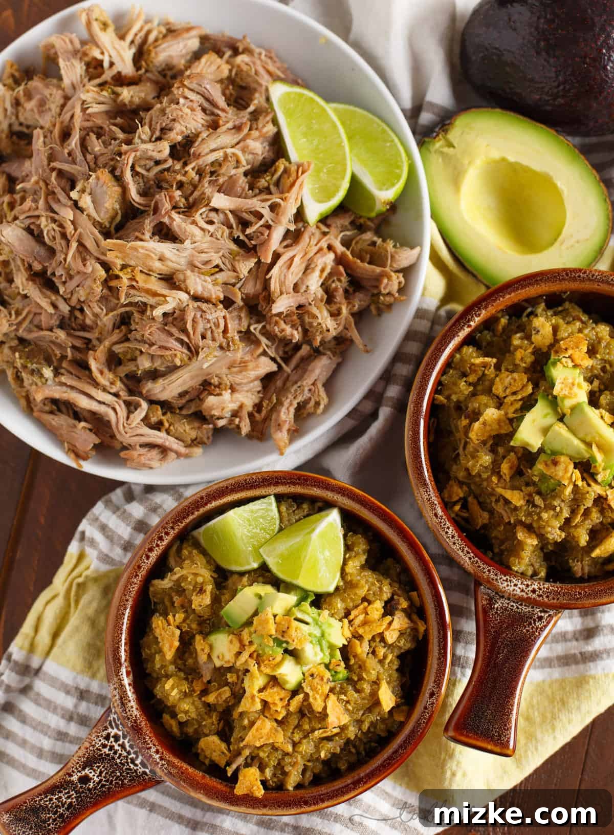 Zesty Slow Cooker Poblano Tomatillo Shredded Pork with Quinoa 5 Overhead shot of a bowl filled with Slow Cooker Poblano and Tomatillo Shredded Pork and Quinoa, generously topped with diced avocado, crushed tortilla chips, and a sprinkle of fresh cilantro. The composition highlights the vibrant colors and appealing textures of the final dish, inviting diners to enjoy a hearty and wholesome meal.