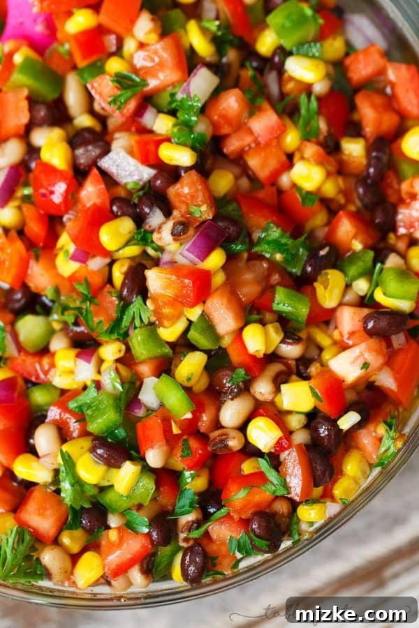Southwest Fiesta Salad 3 A close-up shot of colorful Cowboy Caviar in a bowl, showing diced tomatoes, corn, beans, and peppers.