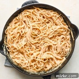 Fiery Cajun Chicken Alfredo 6 spaghetti pasta tossed in cajun alfredo sauce in a cast iron skillet