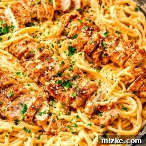 Fiery Cajun Chicken Alfredo 2 Cajun chicken alfredo with sliced chicken on top of pasta in cast iron skillet