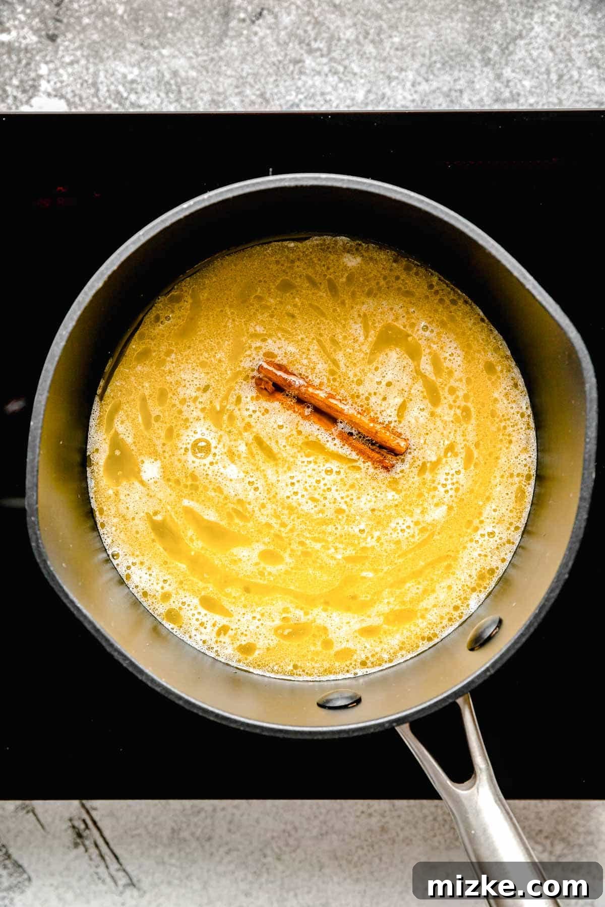 melted butter and a cinnamon stick in a saucepot