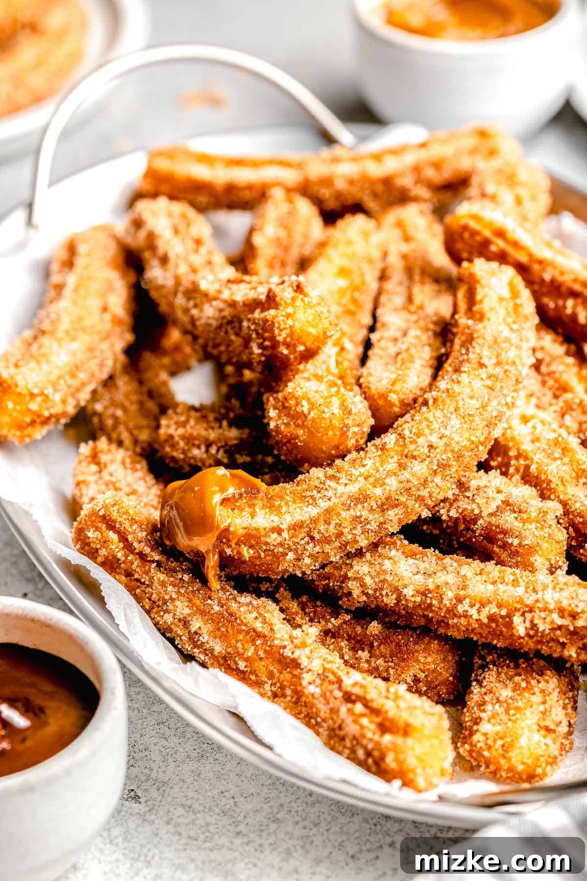 a mexican churro with caramel sauce on the tip