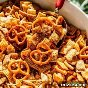 Homemade Chex Mix scooped from a bowl, ready to be served