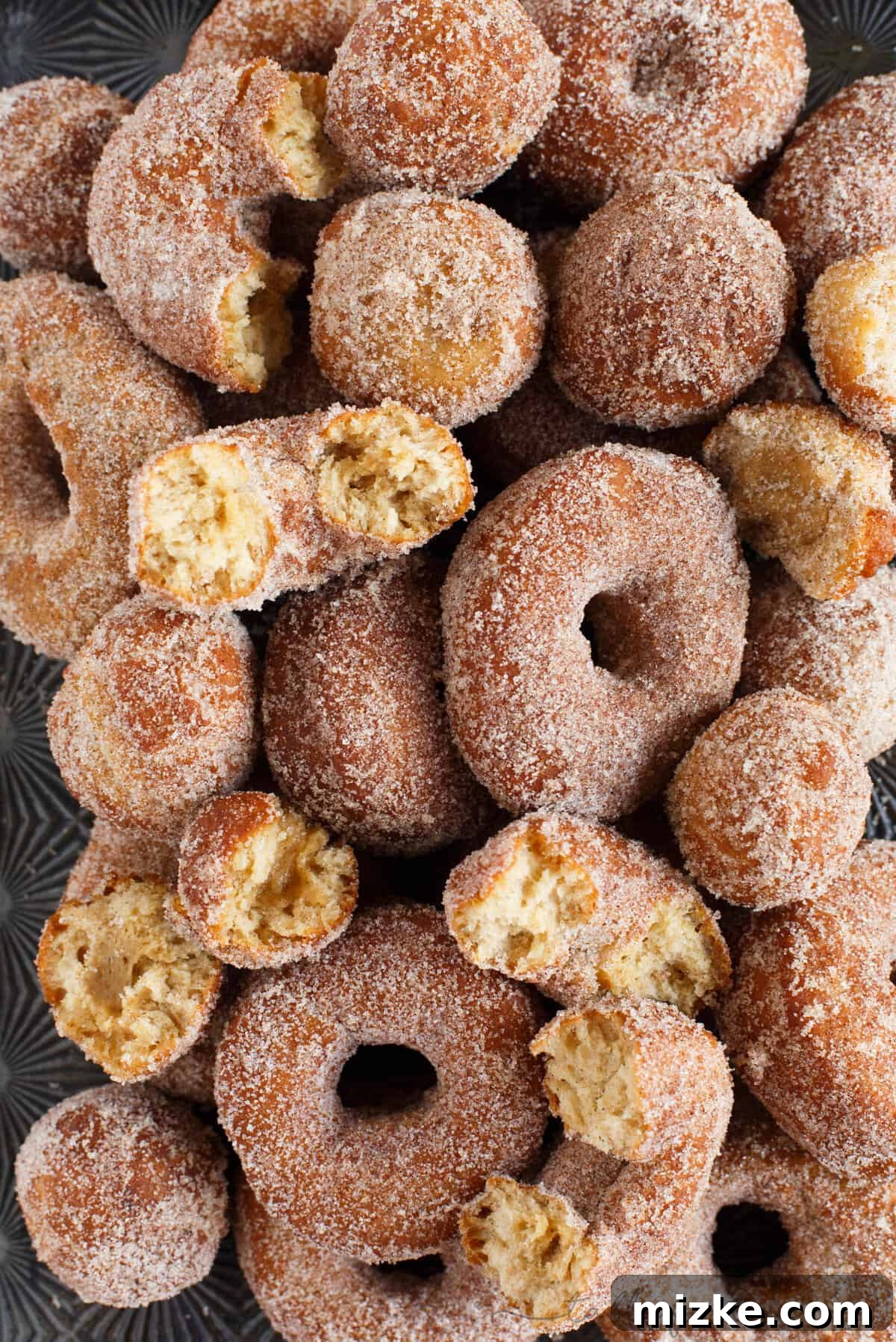 Spiced Apple Cider Doughnut Delights 3 Apple cider doughnuts piled on baking sheet, ready for serving