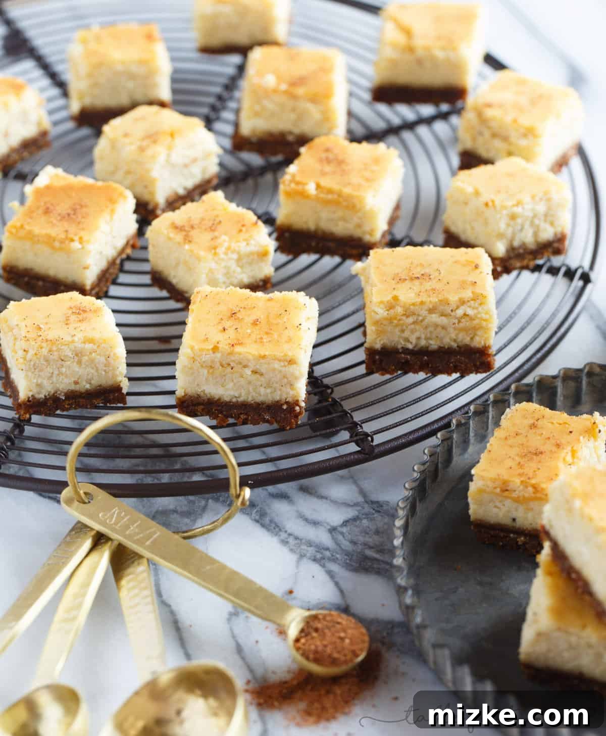Gingersnap-Crusted Eggnog Cheesecake Bites 2 Delicious individual eggnog cheesecake bites with gingersnap crust, garnished with fresh nutmeg, perfect for holiday gatherings.
