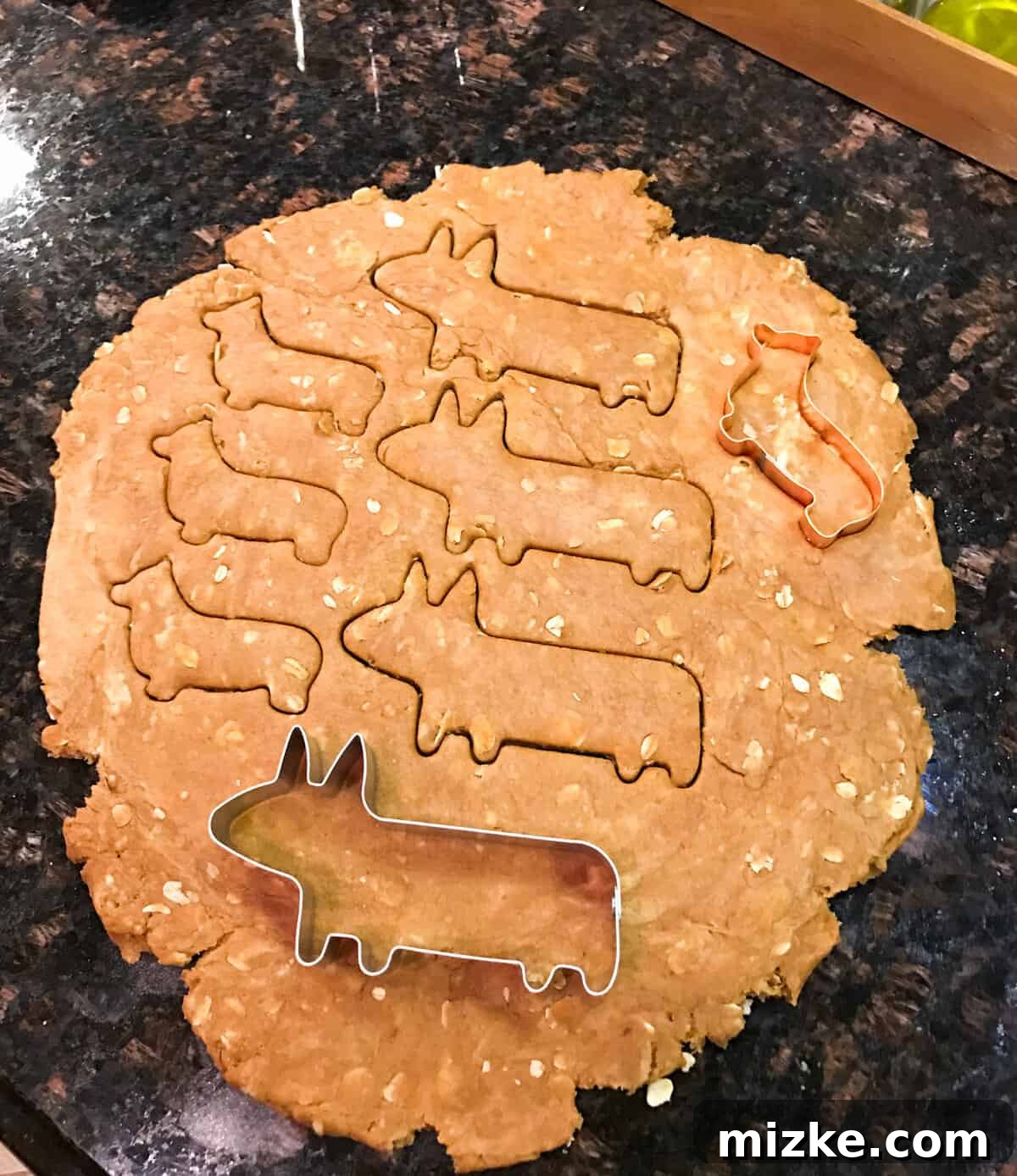 Variety of Corgi-shaped dog biscuits on a baking sheet