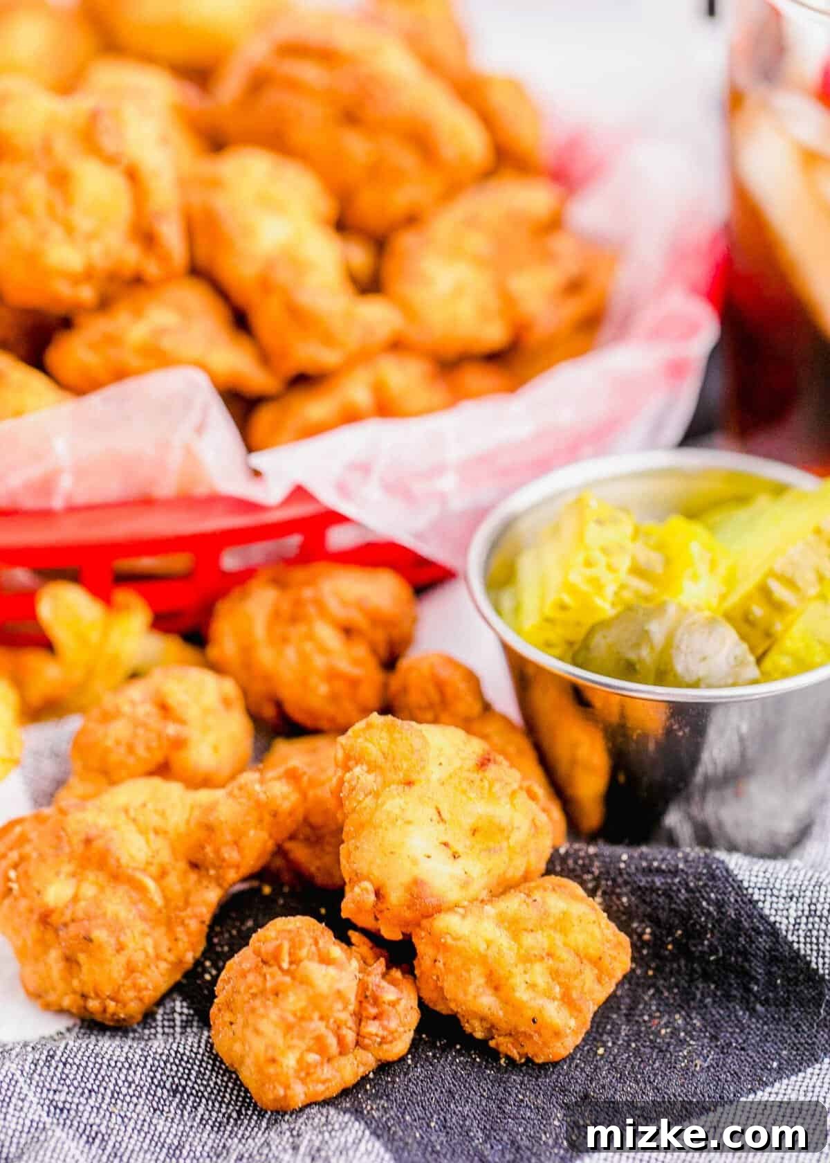 Crispy Homestyle Chick-Fil-A Nuggets 4 Copycat Chick-Fil-A Chicken Nuggets on napkin with basket of nuggets in background