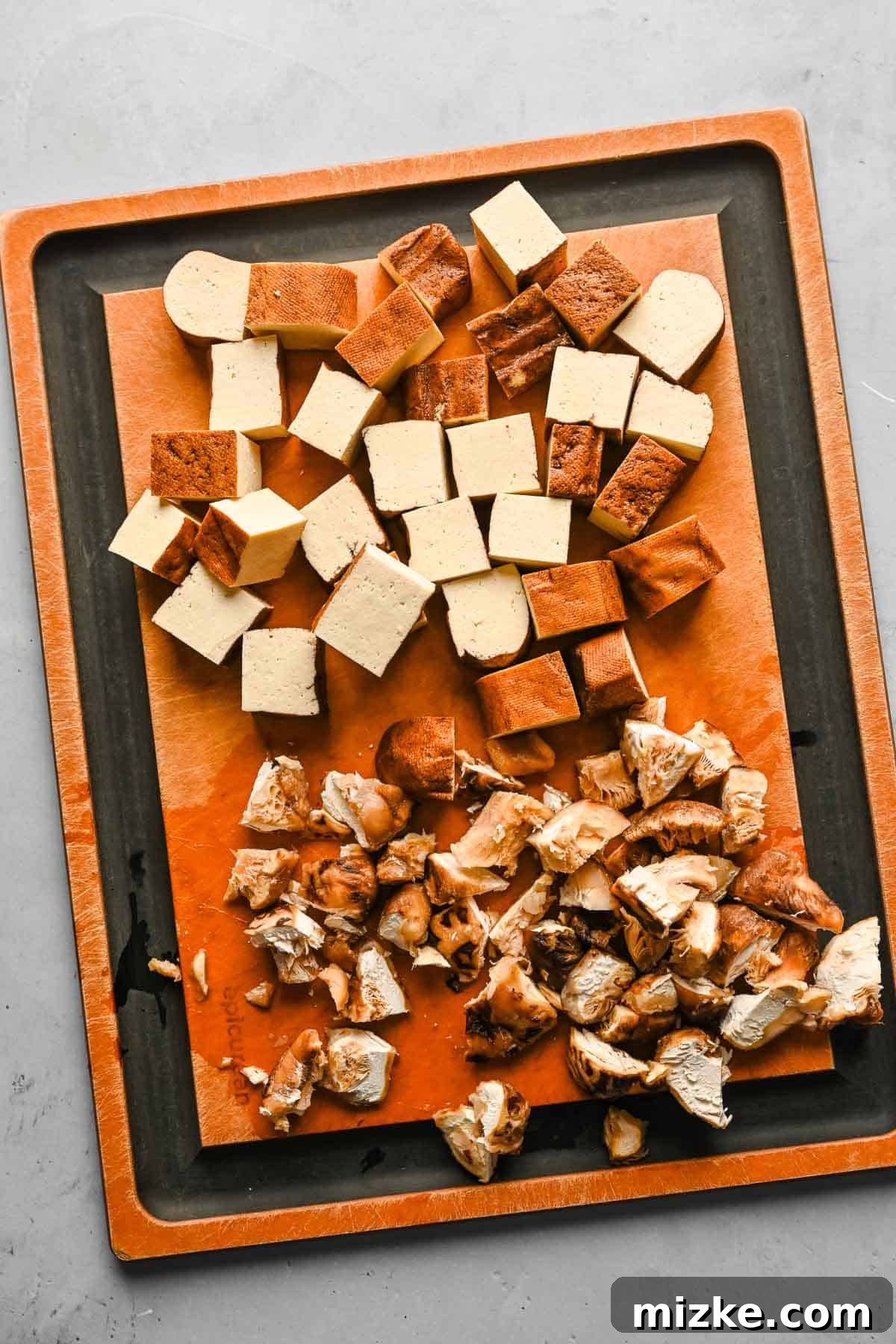 Prepping shiitake mushrooms and tofu for Taiwanese braised minced pork. Finely chopped spiced dry tofu and rehydrated shiitake mushrooms neatly arranged on a wooden cutting board, ready for the braising process.