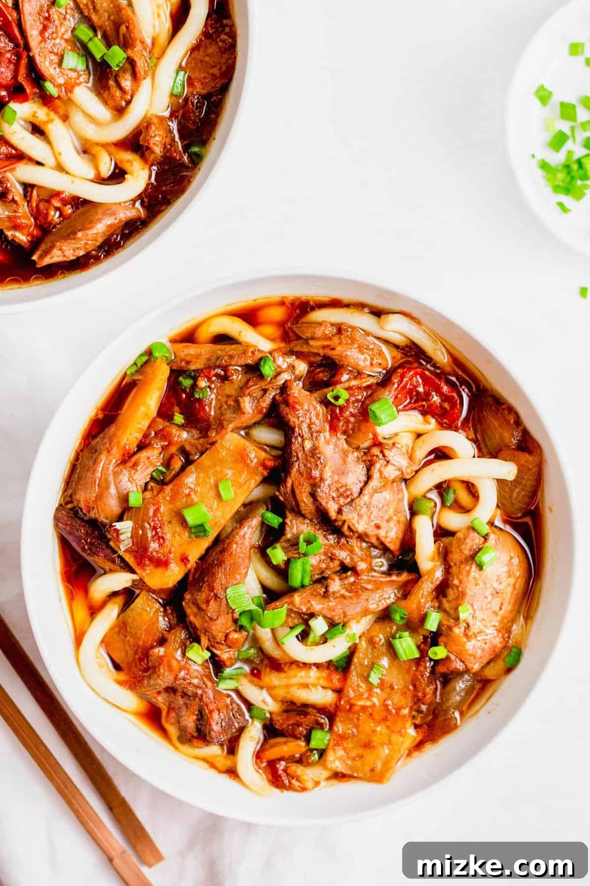 Instant Pot Taiwanese Beef Noodle Soup: Cozy, flavorful, and easy to customize for a quick weeknight meal. Overhead view of two bowls of Taiwanese beef noodle soup topped with fresh green onions, showcasing rich broth and tender beef