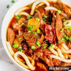Bowl of Taiwanese beef noodle soup topped with minced green onions
