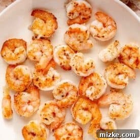 Glazed Honey Garlic Shrimp Stir Fry 8 Shrimp being cooked in a skillet until browned and crispy, demonstrating the proper cooking technique.