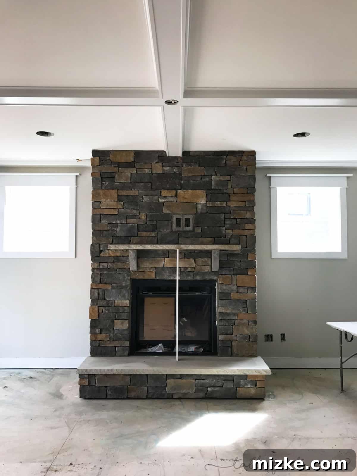 The Final Push 6 Luxurious living room featuring a stunning stone fireplace, focal point of the new construction home.
