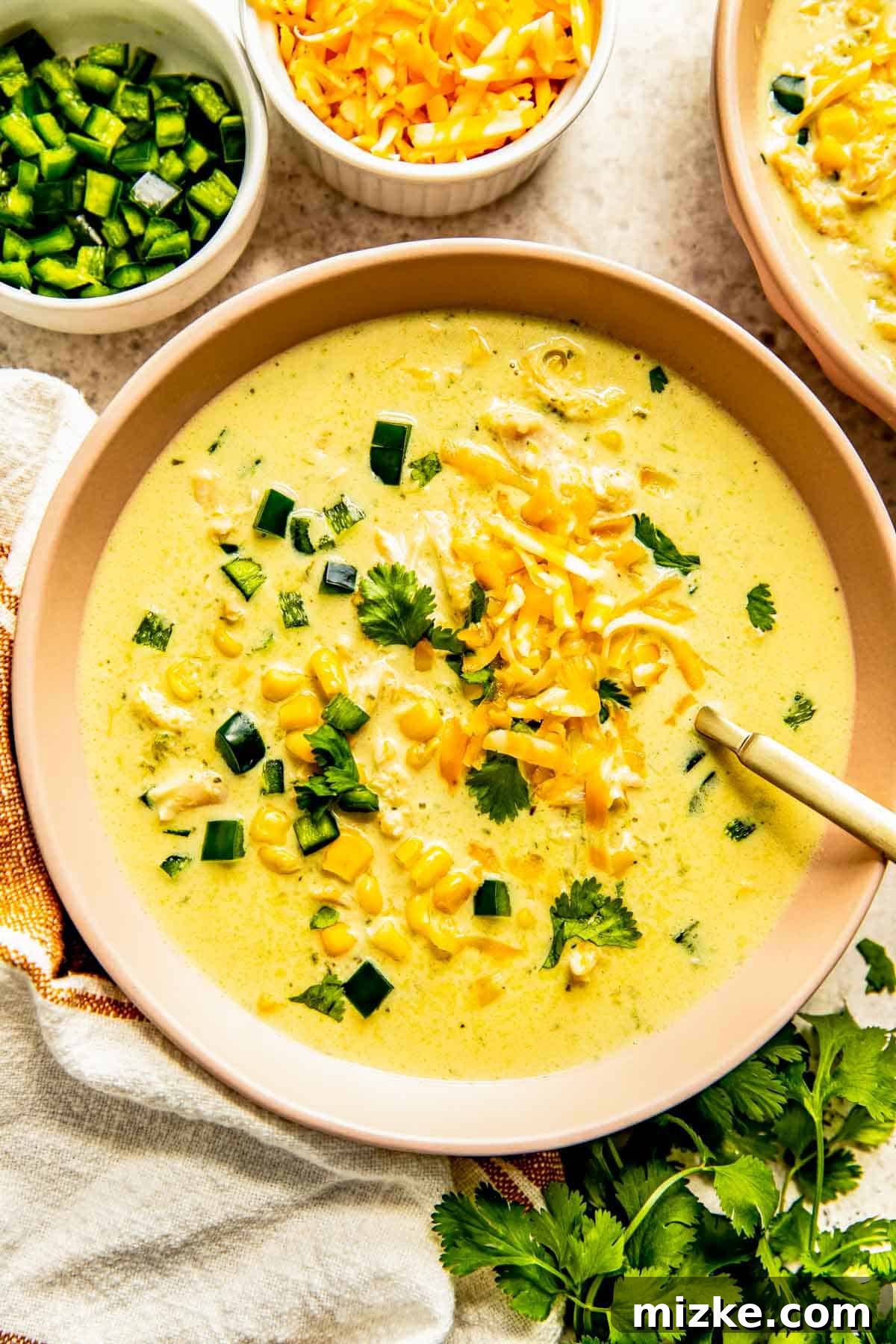 Southwest Chicken Poblano Chowder 2 A vibrant bowl of creamy chicken poblano soup, garnished with fresh cilantro and shredded cheese, ready to be enjoyed.