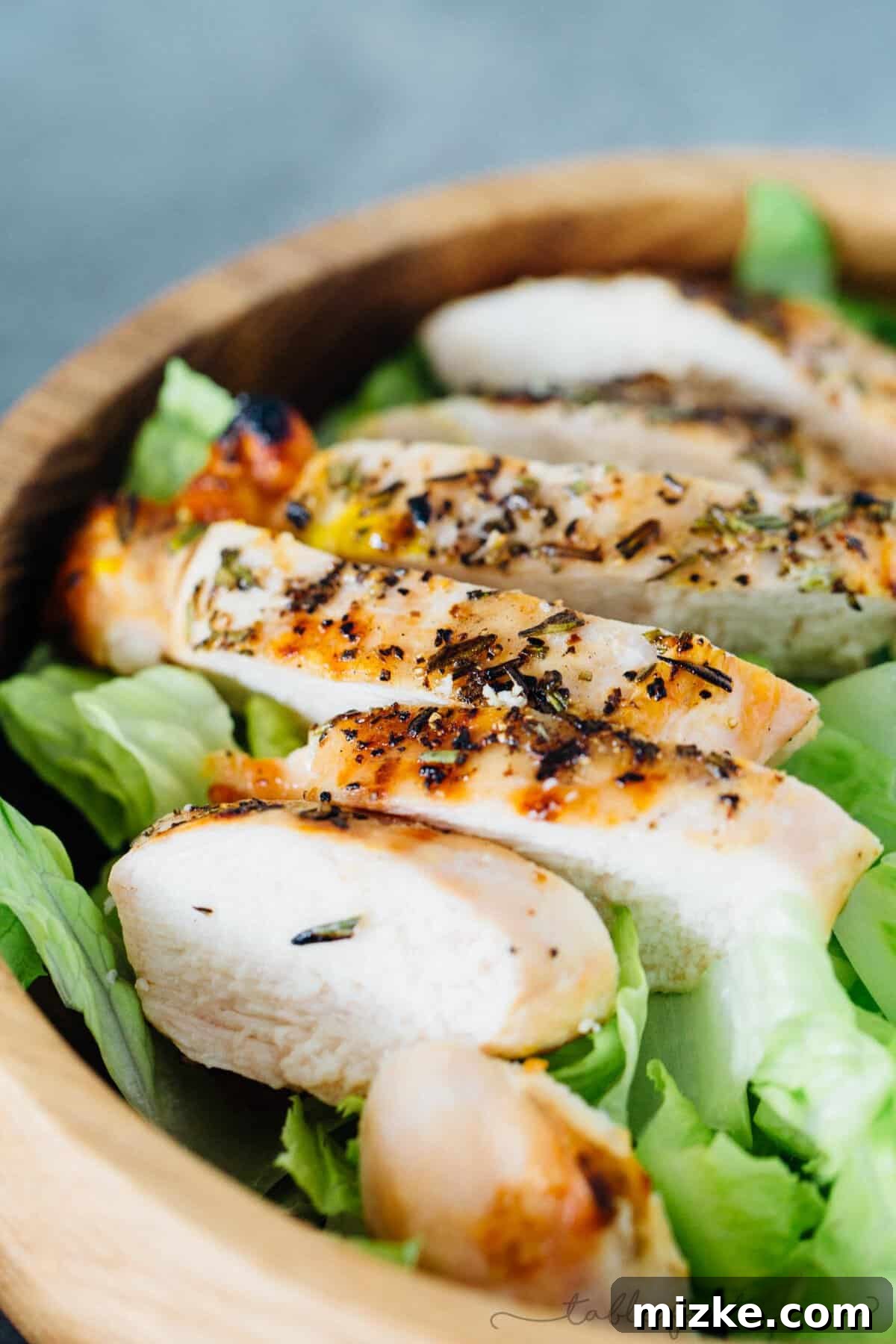 Chargrilled Rosemary Chicken Salad 6 Slicing a perfectly grilled rosemary chicken breast, showing its juicy interior.