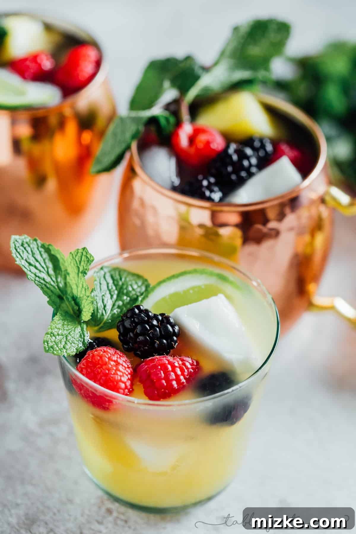 Caribbean Mule 2 A tall copper mug filled with a vibrant Tropical Moscow Mule, garnished with a pineapple wedge and a lime slice, hinting at a fruity twist on the classic cocktail.