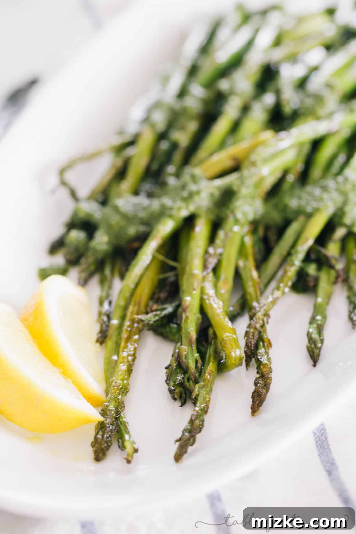Lemon Kissed Pesto Roasted Asparagus 4 A serving platter filled with numerous spears of roasted asparagus, beautifully coated in lemony pesto, ready to be served.