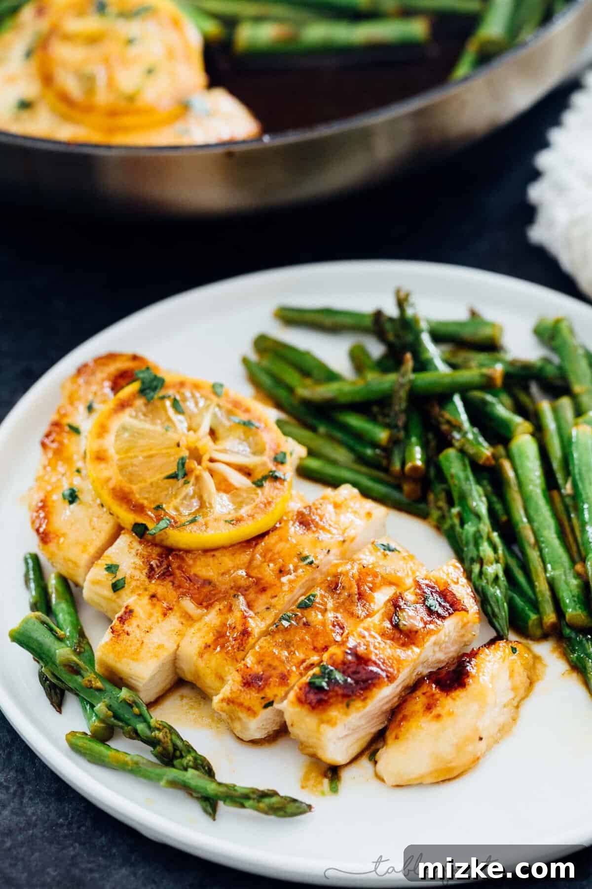 Zesty Honey Butter Chicken with Tender Asparagus 4 One-skillet Honey Butter Lemon Chicken and Asparagus, garnished with lemon slices.