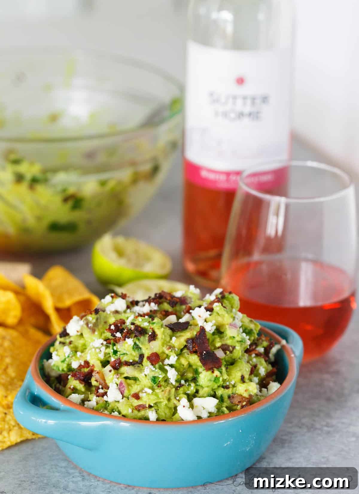 Smoked Poblano and Black Pepper Bacon Guac 3 Close-up of the chunky, flavorful texture of charred poblano, bacon, and queso fresco mixed into creamy avocado, showcasing the rich ingredients.