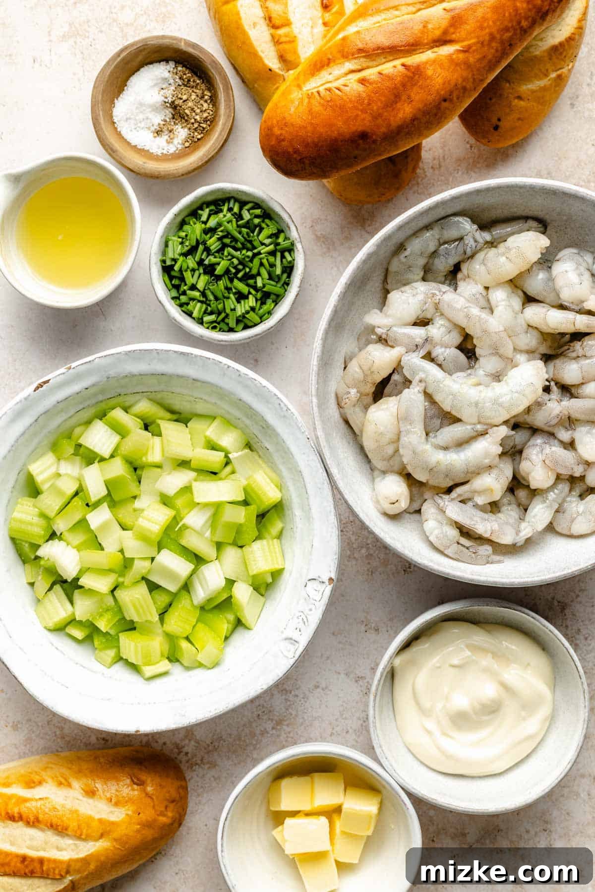 Savory Shrimp Wraps 3 A vibrant flat lay of fresh ingredients beautifully arranged for making shrimp rolls, including cooked shrimp, crisp celery stalks, whole lemons, a bowl of creamy mayonnaise, fresh chives, and golden brioche buns.