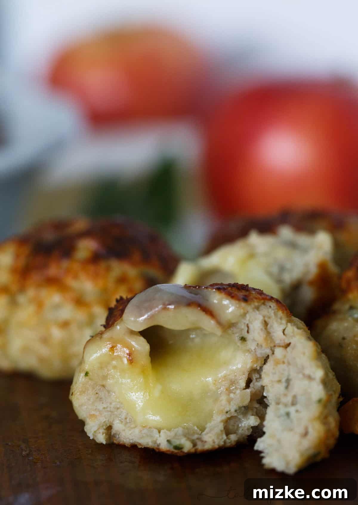 Autumn Harvest Chicken Meatballs with Apple Sage and a Cheesy Core 2 Golden-brown stuffed chicken meatballs with apple and sage, revealing melted brie cheese center
