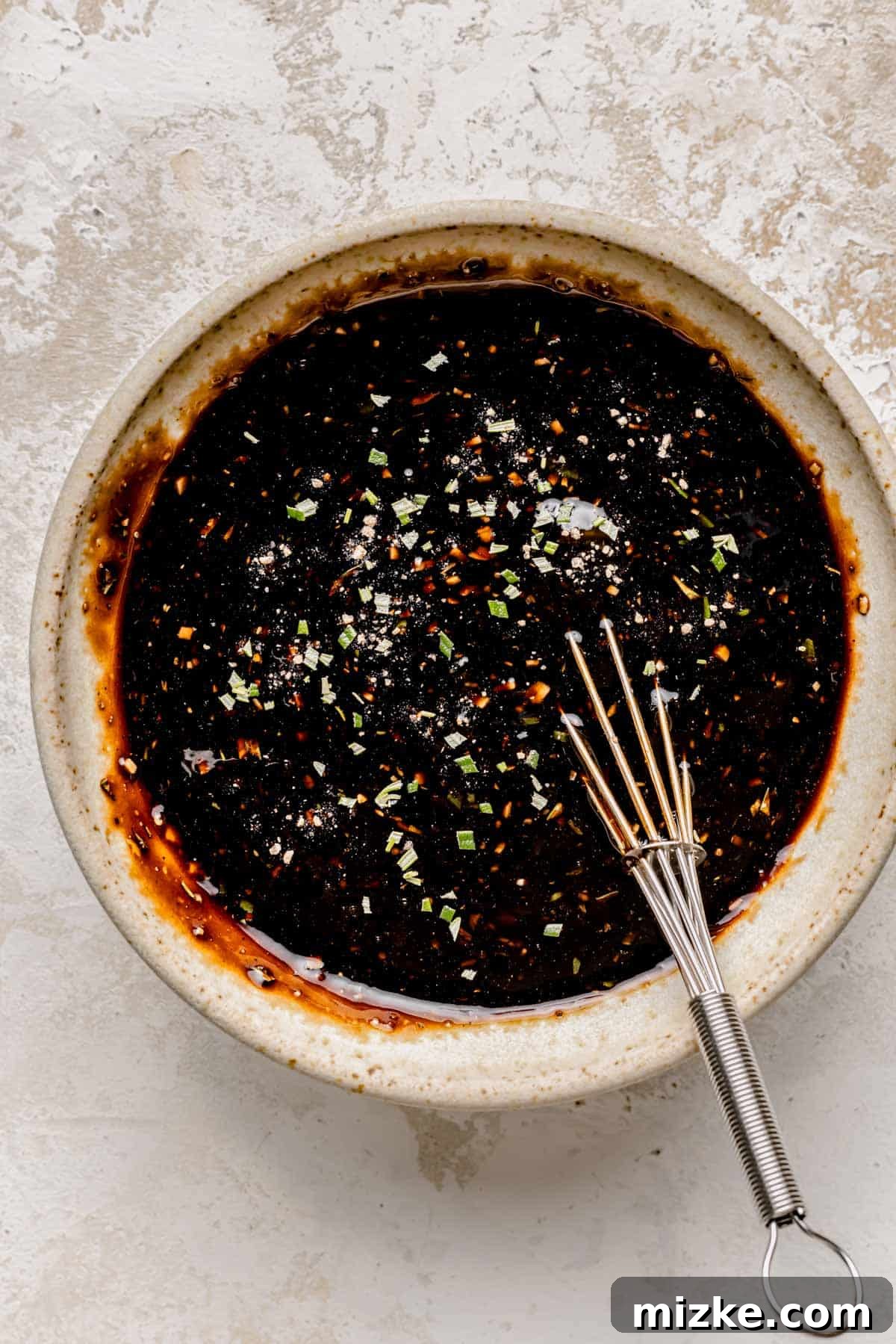 Caramelized Fig Chicken Skillet 6 The sweet and tangy fig balsamic glaze is being whisked together in a bowl, combining balsamic vinegar, fig preserves, and the remaining herbs and spices.