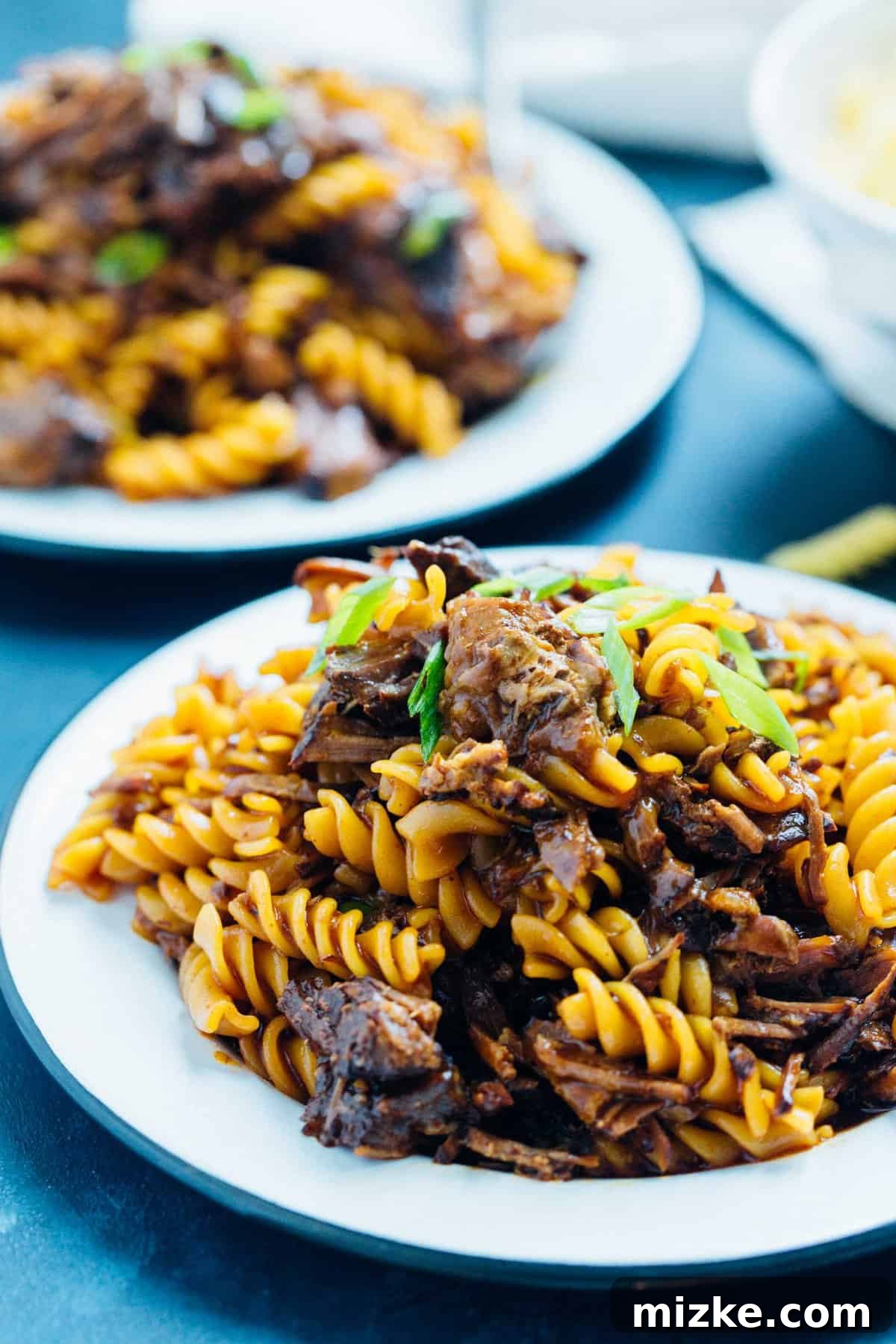 Tender Korean Beef Ragu 3 Overhead shot of Instant Pot Braised Korean Beef Ragu, with a fork pulling apart a piece of tender beef, highlighting the rich, glossy gochujang-infused sauce.