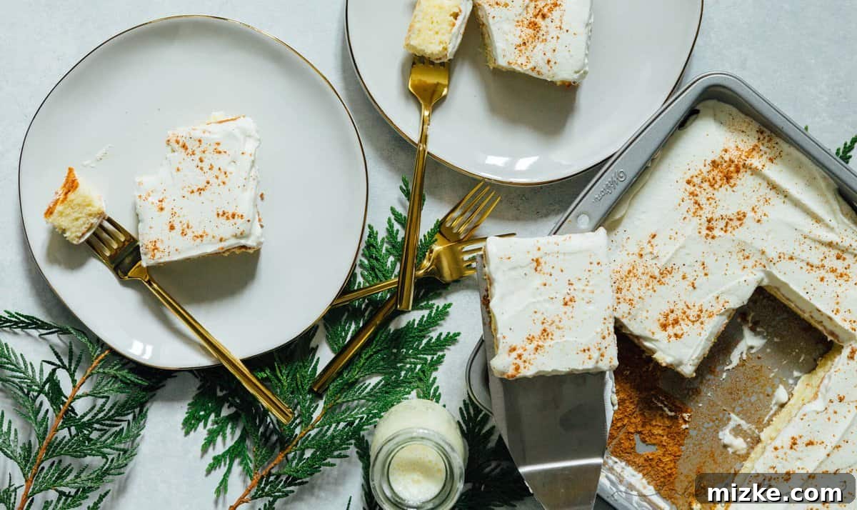 Holiday Eggnog Tres Leches 4 Overhead image of eggnog tres leches cake served out of the baking pan onto white gold rimmed plates with elegant gold forks, ready to be enjoyed.