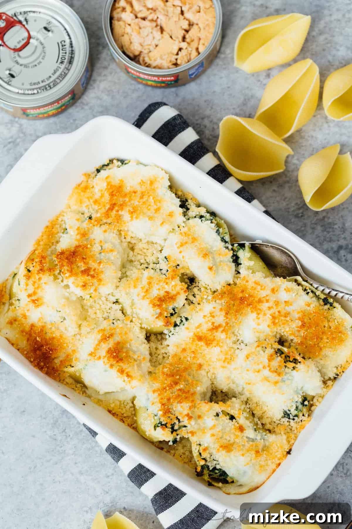 Tuna and Spinach Shell Bake 6 A slice of spinach and tuna stuffed shells pasta casserole on a plate, showing the creamy filling and golden topping.