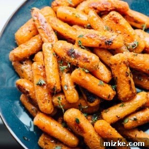 The star of the show: a close-up of golden-brown roasted parmesan carrots, speckled with herbs, perfect for a recipe card.