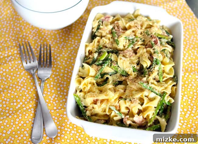 Spring Carbonara with Asparagus, Crispy Pancetta, and Lemon Herb Crumble 2 A beautifully plated dish of creamy Pasta Carbonara, garnished with vibrant green asparagus spears, golden crispy pancetta, and bright lemon herb breadcrumbs, ready to serve.