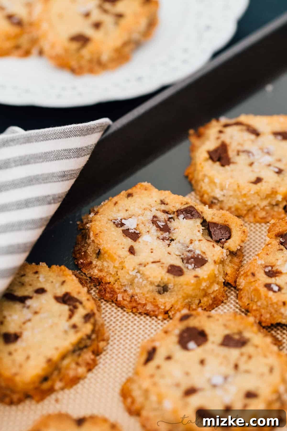 A vibrant display of baked salted shortbread chocolate chunk cookies with a glass of milk, a perfect snack or dessert, symbolizing pure indulgence.