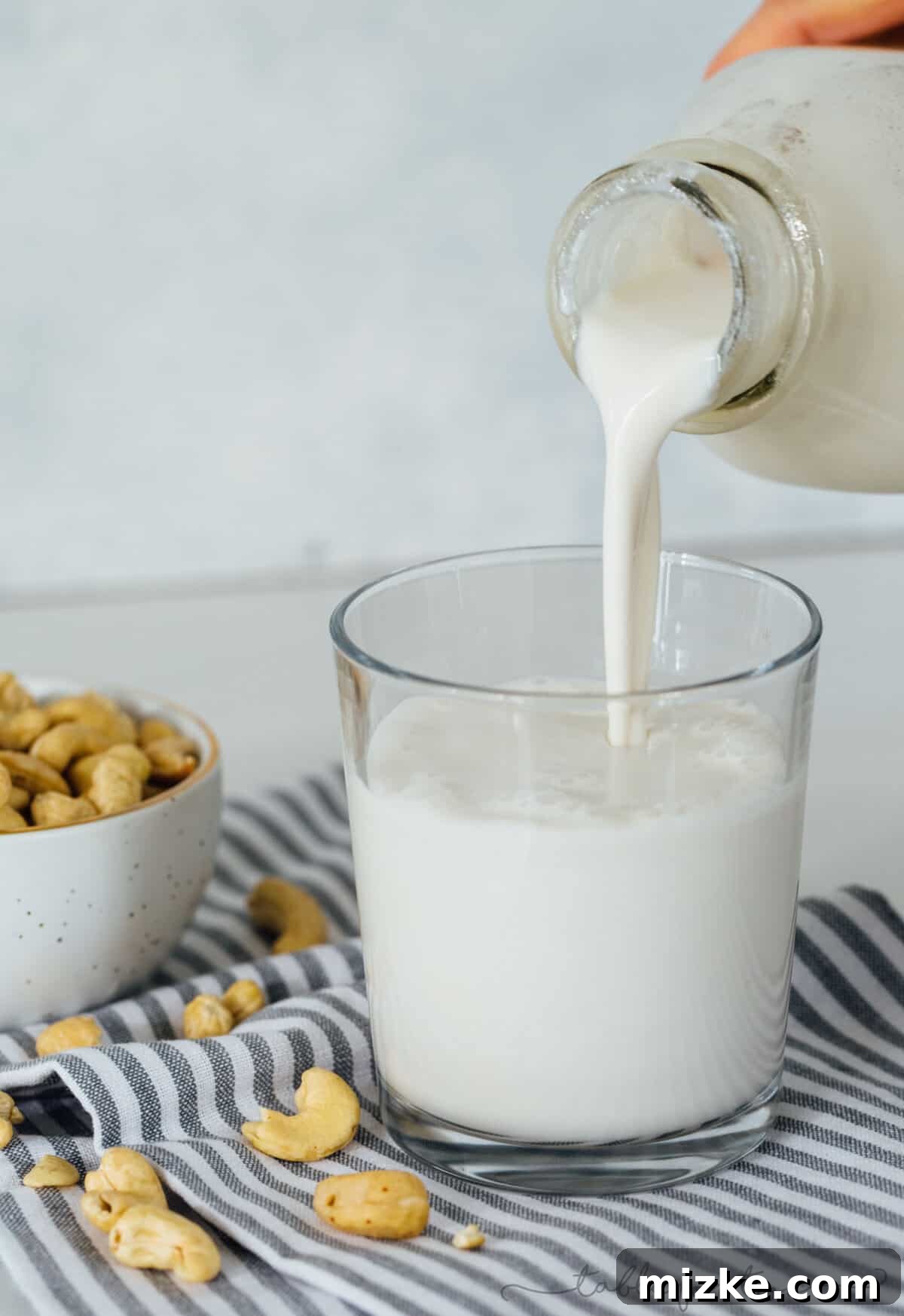 Homemade cashew milk: Rich, creamy, and undeniably delicious for all your plant-based needs. Freshly blended homemade cashew milk poured into a clear glass, highlighting its smooth, creamy texture. Perfect for coffee, smoothies, or drinking plain.