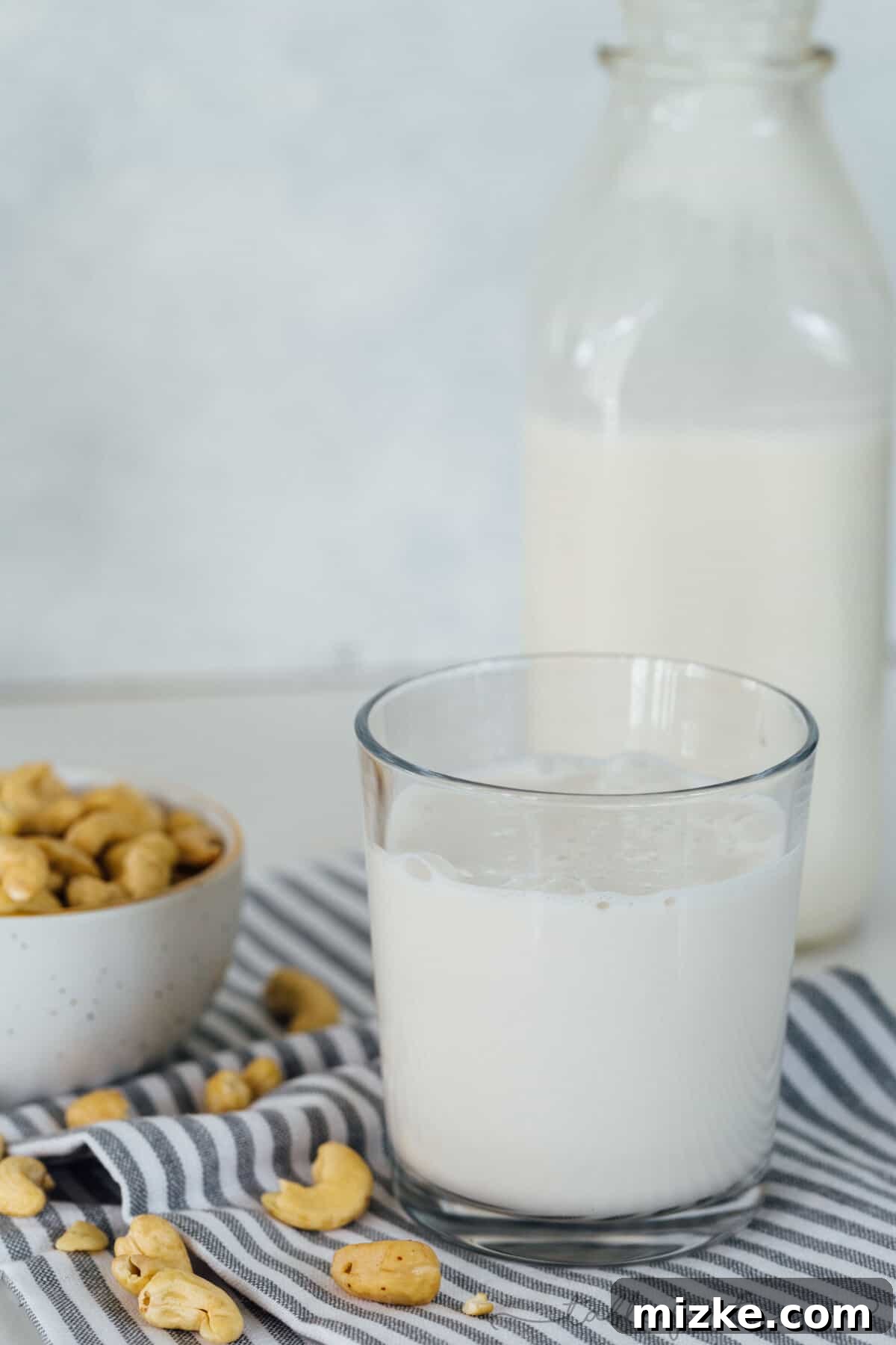 Enjoying fresh homemade cashew milk is a simple pleasure that tastes gourmet. A beautifully clear glass bottle filled with freshly prepared homemade cashew milk, ready for refrigeration. Shows the natural, pristine color of the milk and its appealing consistency.