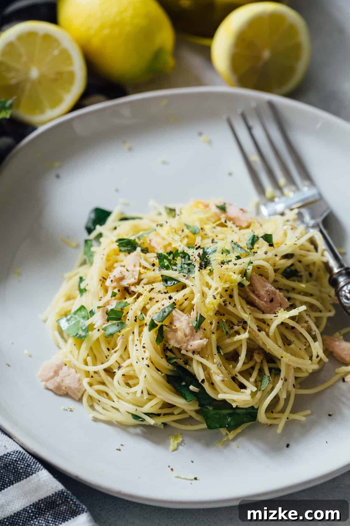 Sunshine Tuna Pasta 4 A beautifully plated bowl of zesty tuna pasta, elegantly garnished with fresh herbs and a vibrant lemon slice.