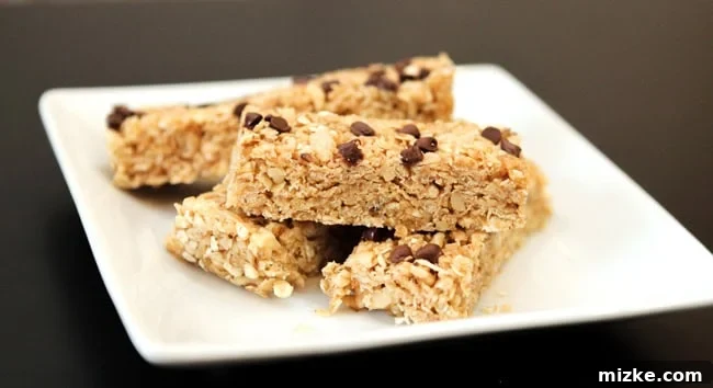 Hearty Chocolate Walnut Granola Bars 4 A baking sheet filled with a dense, unbaked mixture of granola, chocolate chips, and walnuts, pressed flat and ready for cooling and cutting.