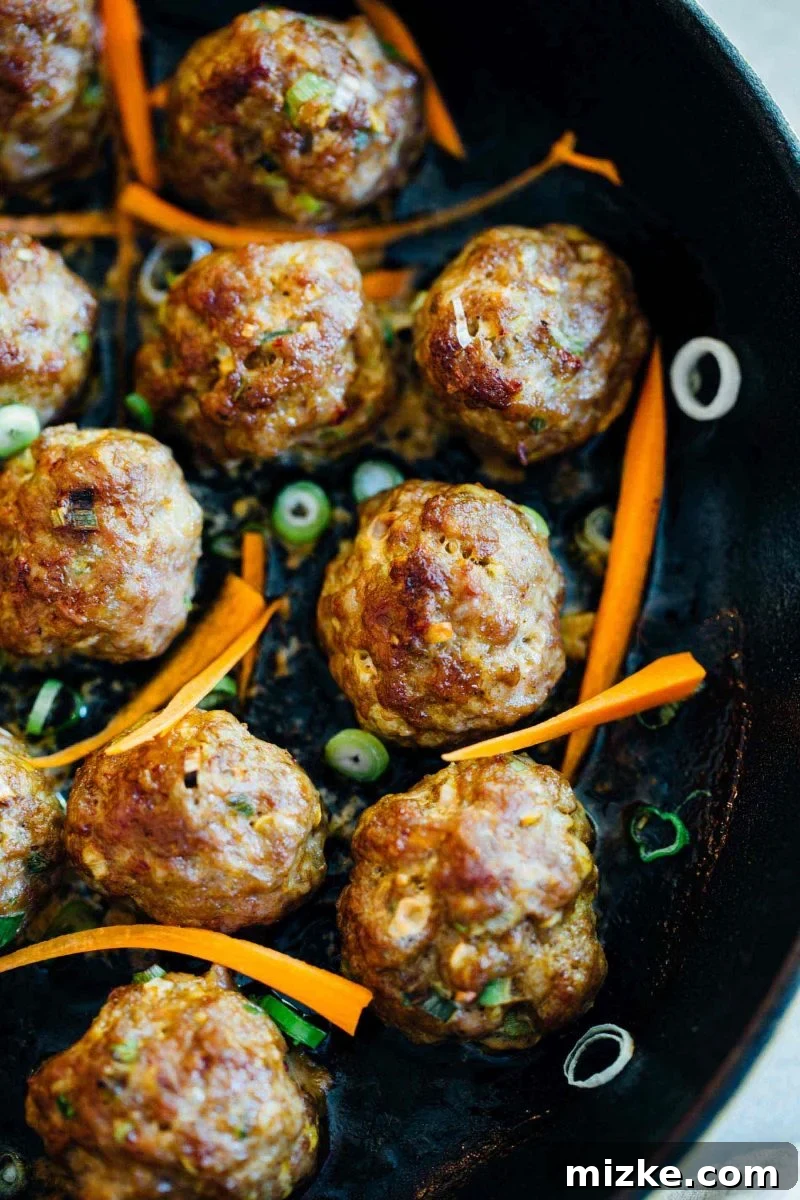 Preparing Asian Pork Meatballs for Baking or Pan-Frying Asian pork meatballs, perfectly formed and ready for cooking to become a delicious meal or appetizer.
