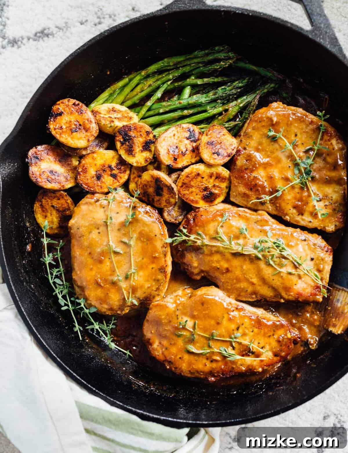 Skillet Apricot Balsamic Pork Chops with Creamy Glaze Close-up of skillet-cooked apricot balsamic pork chops with the rich, reduced glaze, garnished with fresh thyme. #apricotbalsamic #porkrecipe #skilletmeal #deliciousdinner #easycooking