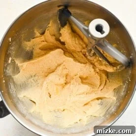 Heavenly White Chocolate Chip Cookies 8 Eggs beaten into the butter and sugar mixture in a metal stand mixer bowl.