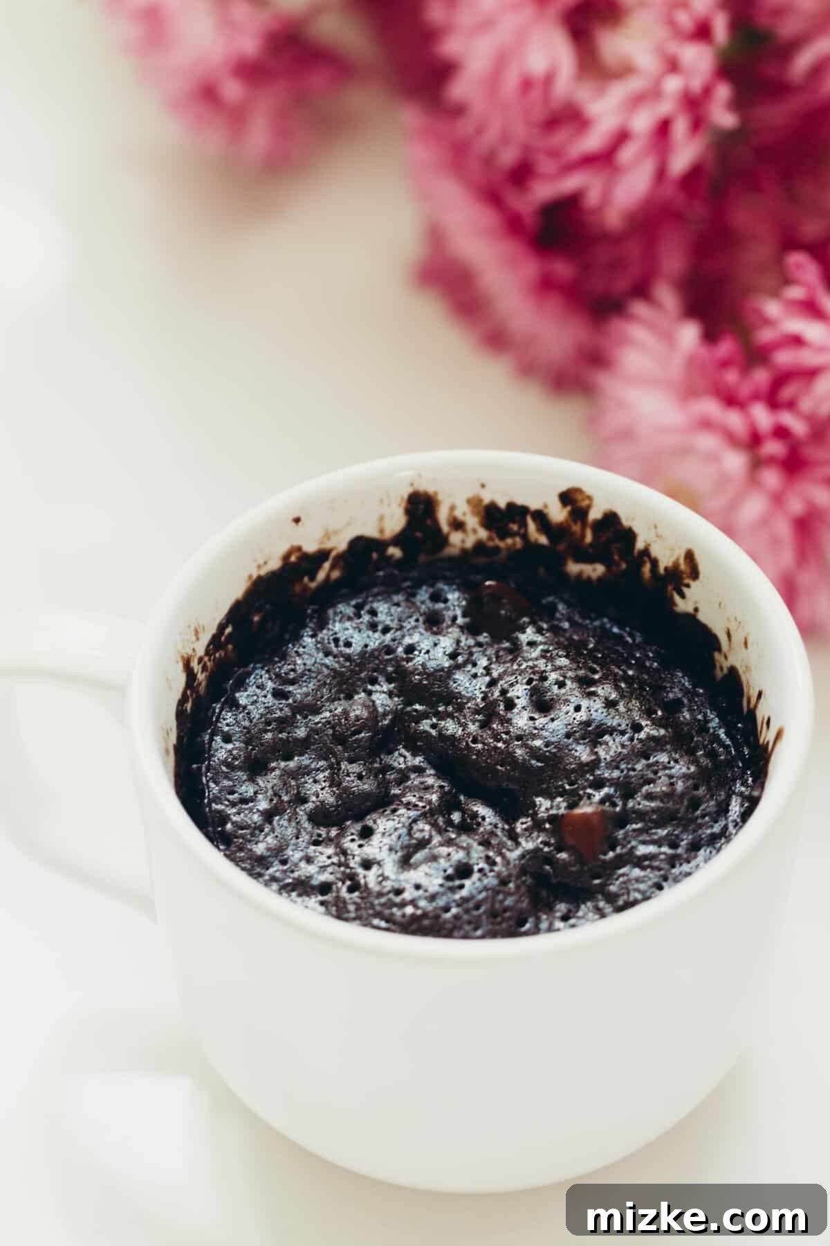 Dark Chocolate Mug Cake: Your ultimate quick, single-serving indulgence. A perfectly portioned dark chocolate mug cake, topped with a scoop of ice cream, hinting at its rich, gooey texture. Keywords: dark chocolate, cake in a mug, mug cake, chocolate mug cake, dessert for one, single serving, quick dessert.