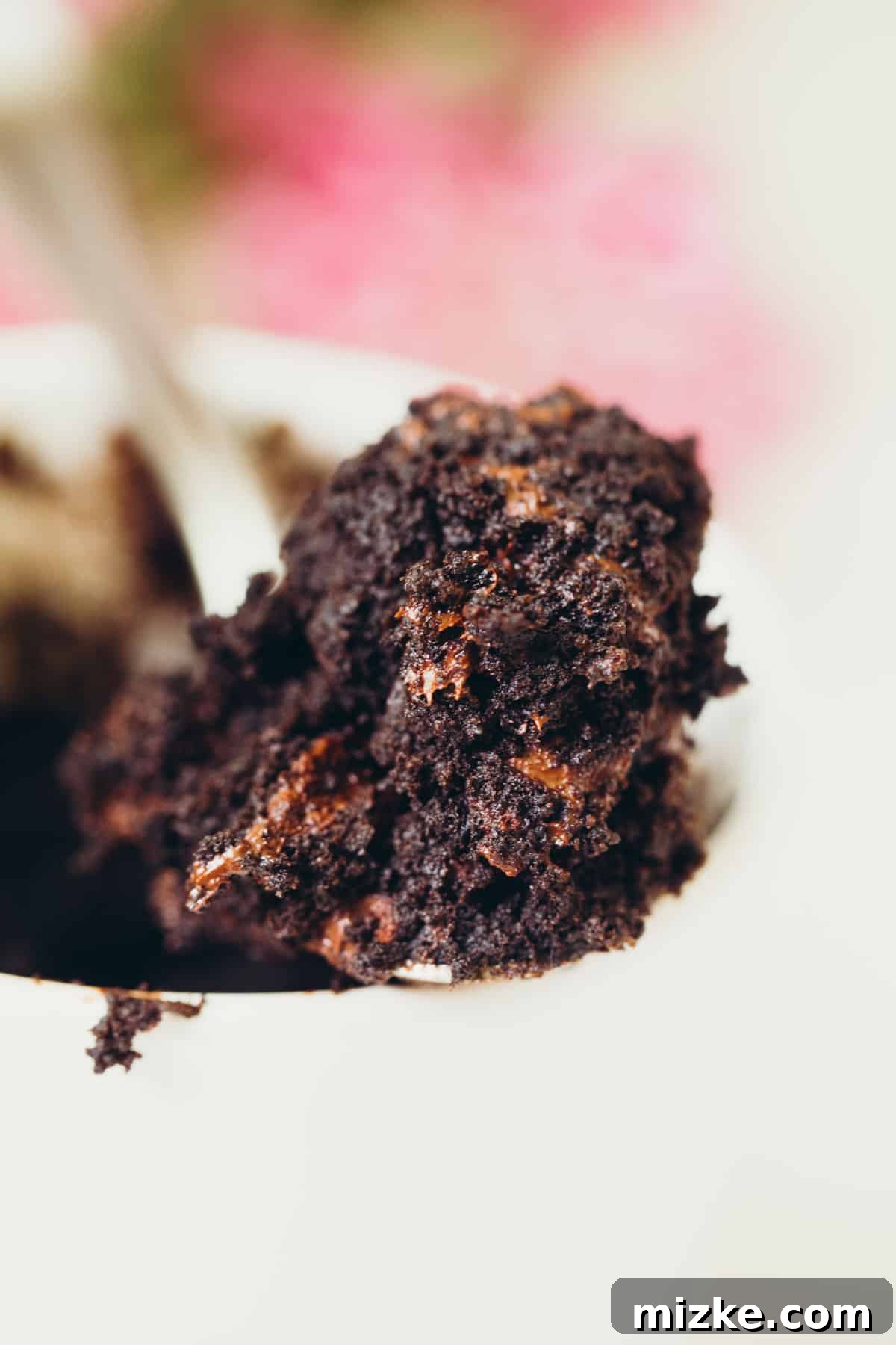 A warm and comforting Dark Chocolate Mug Cake, ready in minutes. Overhead shot of a dark chocolate mug cake, showcasing its rich brown color and steam rising, indicating it's fresh out of the microwave. Keywords: dark chocolate, cake in a mug, mug cake, chocolate mug cake, dessert for one, single serving, quick dessert.