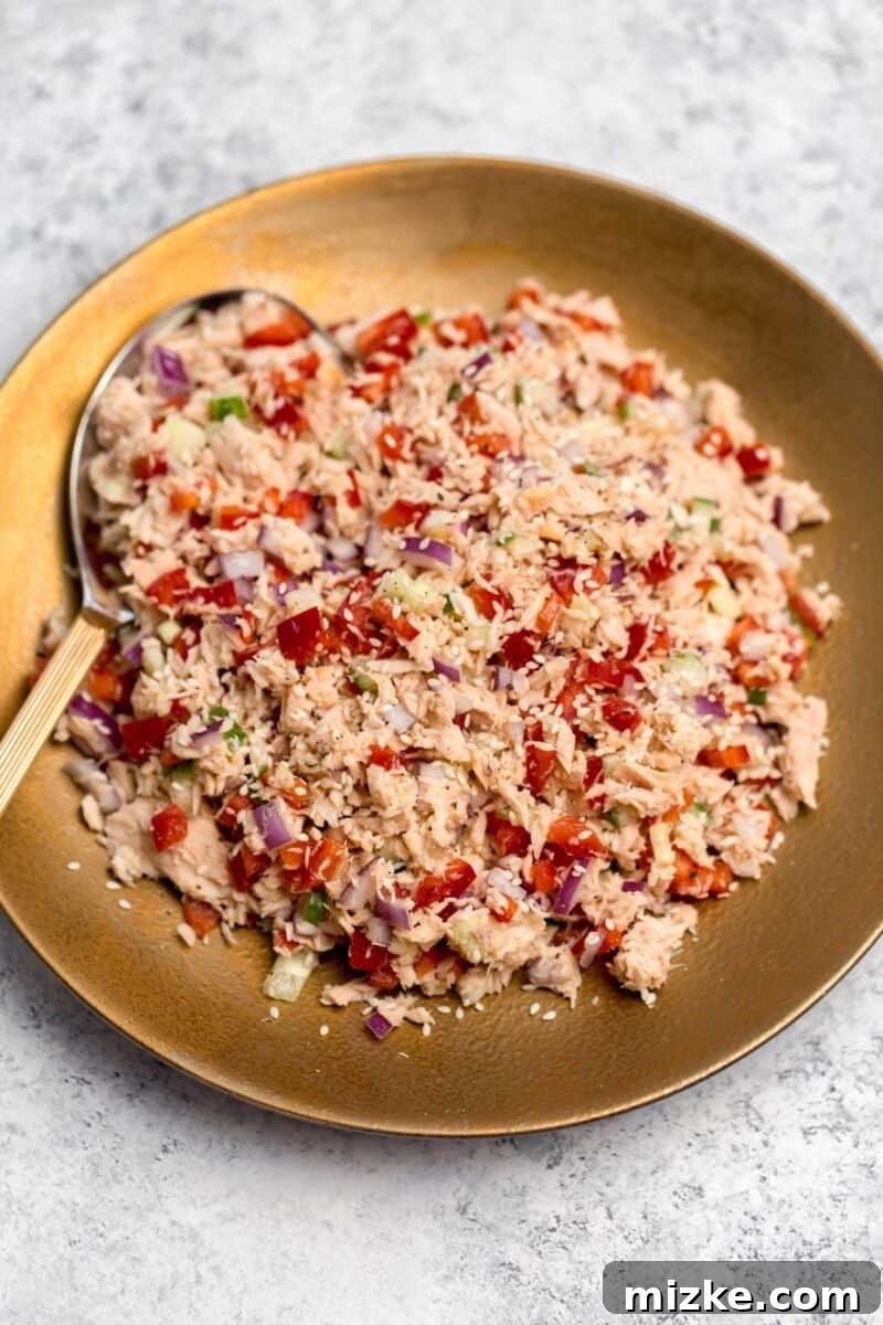 Vibrant Thai Tuna Salad 5 A single serving of Thai Tuna Salad in a small bowl, garnished with sesame seeds and a lime wedge, ready to be enjoyed as a quick, healthy meal.
