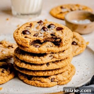 A stack of golden brown butter chocolate chip cookies presented on a plate, highlighting their appetizing appearance.