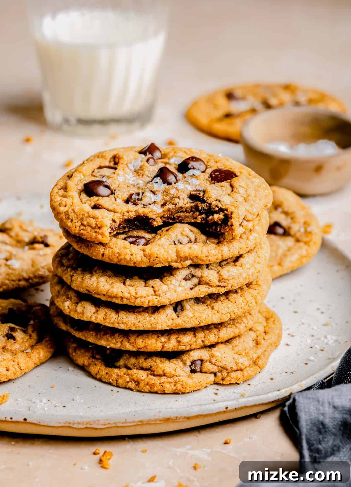 Caramelized Butter Chocolate Chip Cookies 4 A stack of freshly baked brown butter chocolate chip cookies artfully arranged on a plate, showcasing their inviting texture.